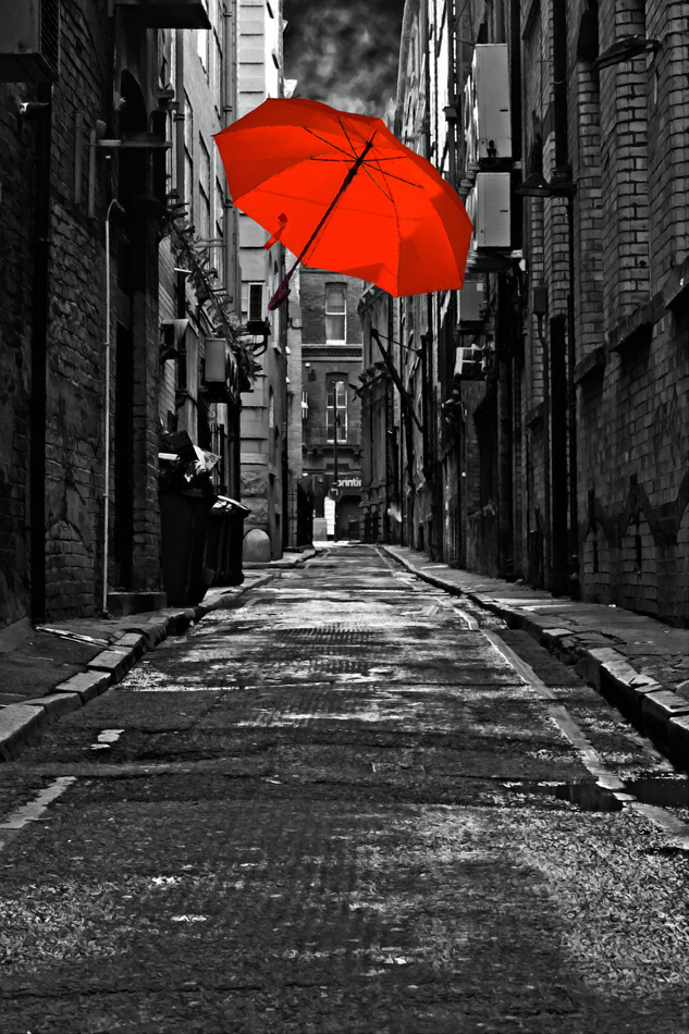 A digitally constructed painting of a colorful umbrella in a dark back 
street