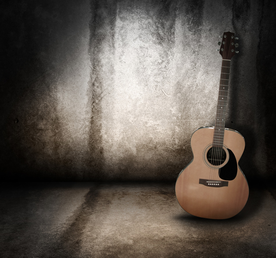 Wooden acoustic guitar on grunge textured wall