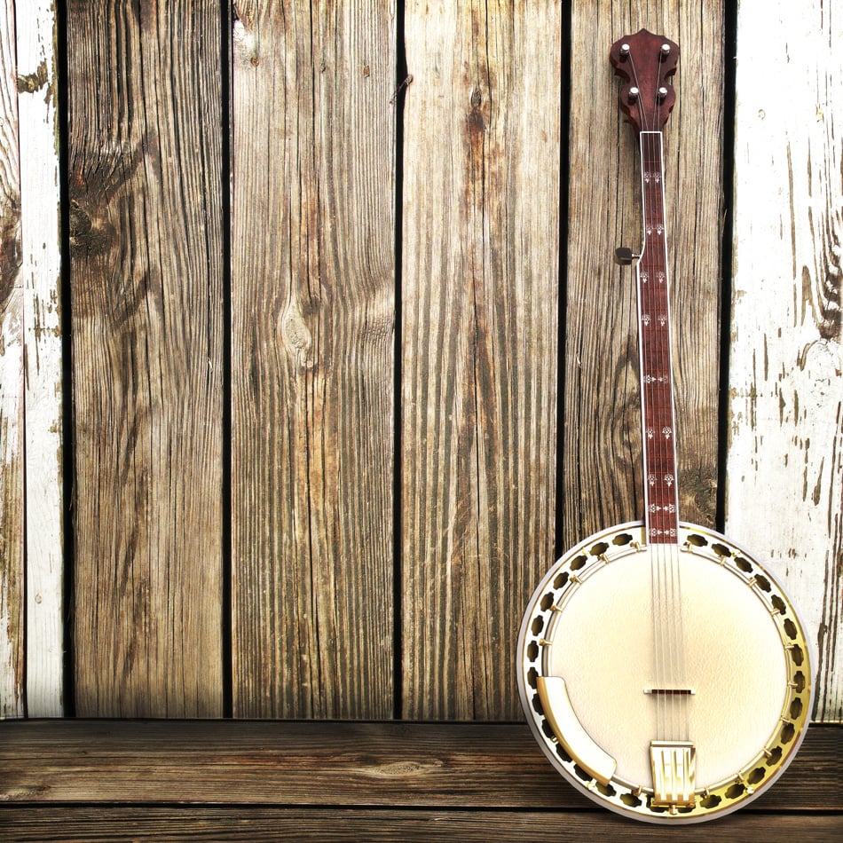 A Banjo leaning on a wooden fence Advertisement with room for text