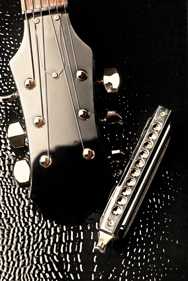 close-up of electric guitar headstock and harmonica