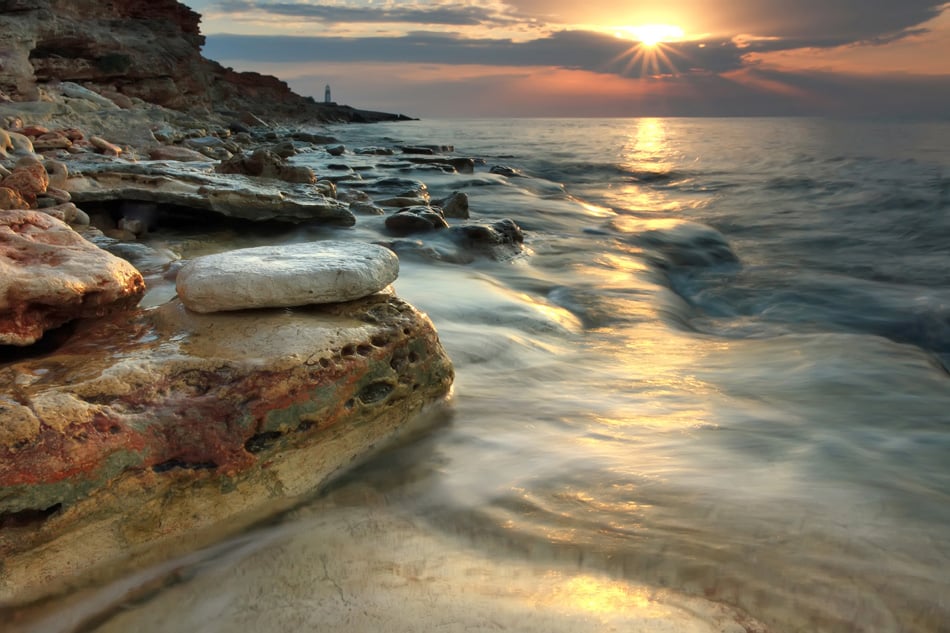 Beautiful rocky sea beach at the sunset in the summer