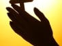 Female Hands With Crucifix - On Yellow Background