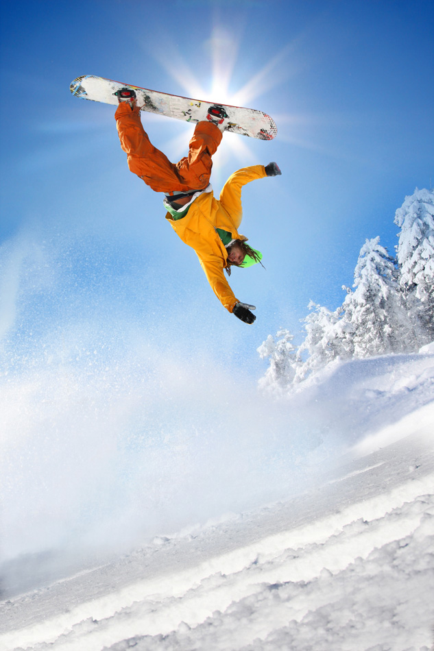 Snowboarder jumping against blue sky 1