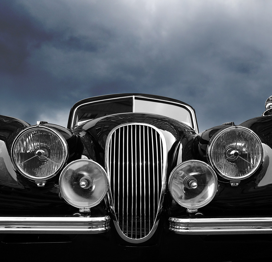 Vintage classic car front view with dark clouds