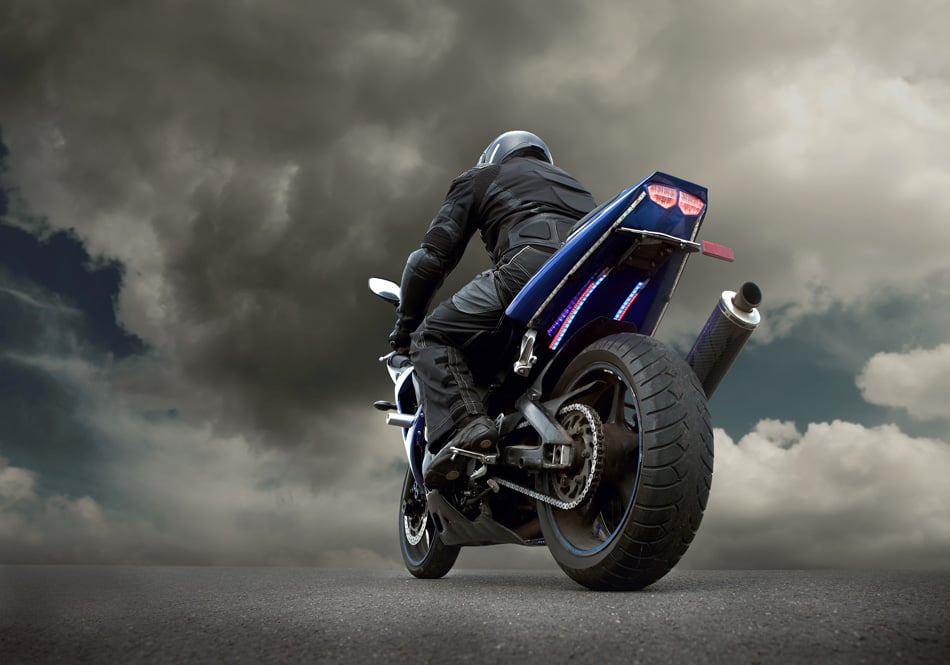 Man Seat On The Motorcycle Under Sky With Clouds