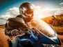 Biker In Helmet And Leather Jacket Racing On The Road