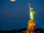 Statue of Liberty and a rising supermoon in New York City