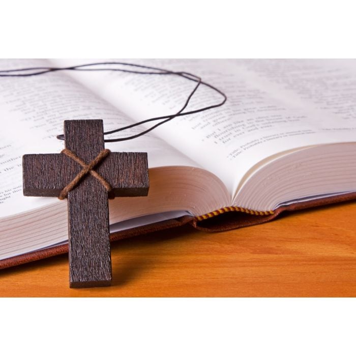 A Wooden Cross Resting Against The Holy Bible - ID # 6624668