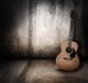Wooden acoustic guitar on grunge textured wall - ID # 103820699