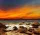 Red sky over a rocky seashore  - ID # 109387061